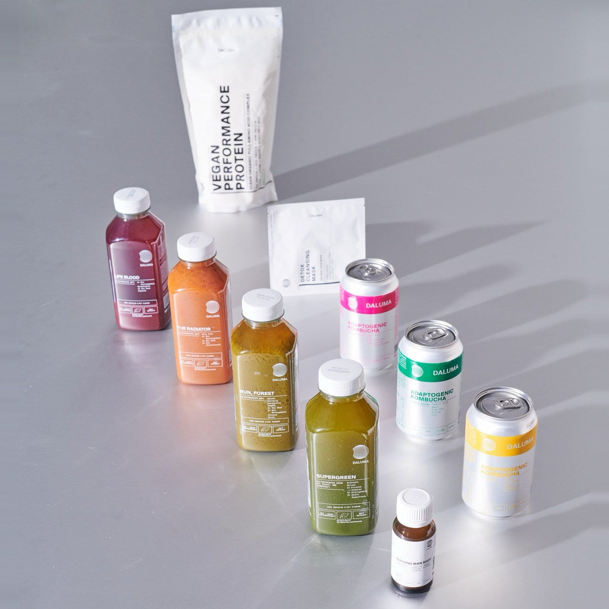 DALUMA Produktrange mit kaltgepressten Säften, Adaptogenic Kombucha, Shot, Vegan Performance Protein und Detox Cleansing Mask.