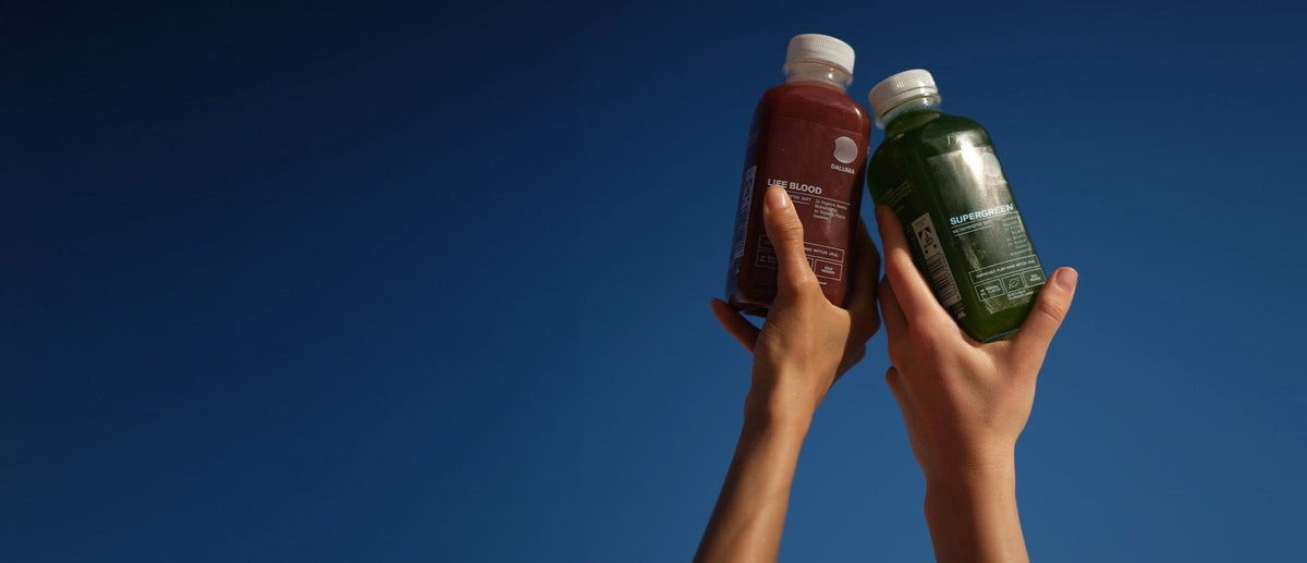 DALUMA Life Blood und Supergreen vor blauem Himmel in die Höhe gehalten.