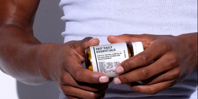 Eine Person in einem weißen Hemd hält eine Flasche mit der Aufschrift 360° Daily Essentials mit beiden Händen, wobei sich das Etikett deutlich von einem schlichten Hintergrund abhebt.