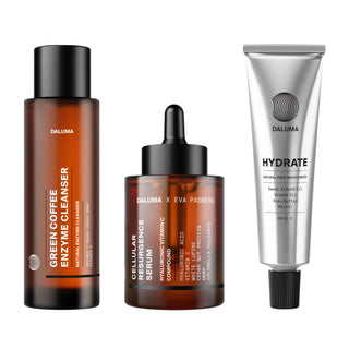 Die ANTI-AGING ESSENTIAL ROUTINE von DALUMA umfasst eine große Flasche Green Coffee Enzyme Cleanser, eine kürzere Flasche Cellular Rejuvenation Serum Tropfflasche und eine silberne Tube Hydrate Natural Face Moisturizer.
