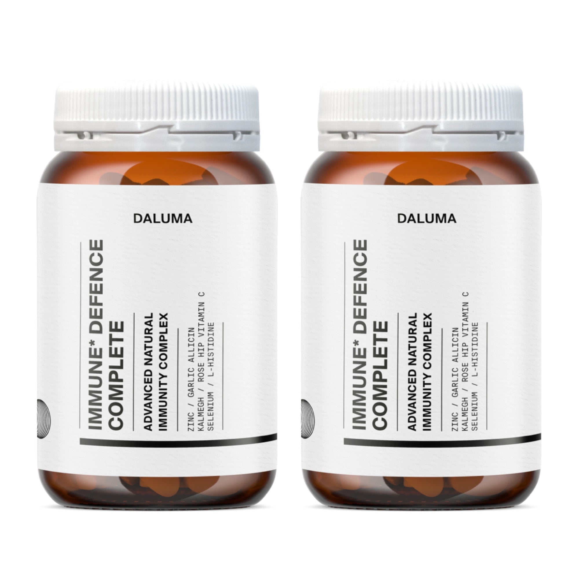 Zwei braune Nahrungsergänzungsflaschen mit weißen Etiketten und Deckeln tragen die Marke DALUMA. Das Produkt, IMMUN DEFENCE COMPLETE KOMPLEX DOUBLE, führt auf dem Etikett die wichtigsten Vitamine und Mineralstoffe zur Unterstützung des Immunsystems auf.