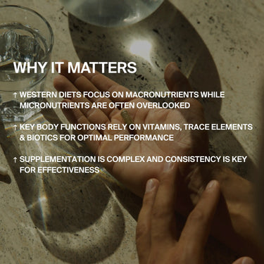 Eine Person hält auf einer sonnenbeschienenen Arbeitsplatte neben einem Glas Wasser DALUMA's Holistic Health Supplement Protokoll Pillen in den Händen, wobei der Text überlagert wird, der die Bedeutung von Mikronährstoffen und Konsistenz für eine optimale Gesundheit betont.