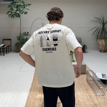 Ein Mann in nachhaltiger Oversize-Passform JOSEPH ATELIER X DALUMA SELFCARE SUNDAY TEE von DALUMA, aus Bio-Baumwolle.