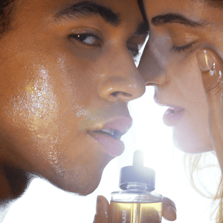 Zwei Menschen mit strahlender, taufrischer Haut stehen sich vertraulich gegenüber, einer hält das DALUMA RADIANT GLAZE GESICHTSÖL. Helles Licht leuchtet hinter ihnen und hebt die strahlende Haut hervor, die von natürlichen Inhaltsstoffen gespeist wird.